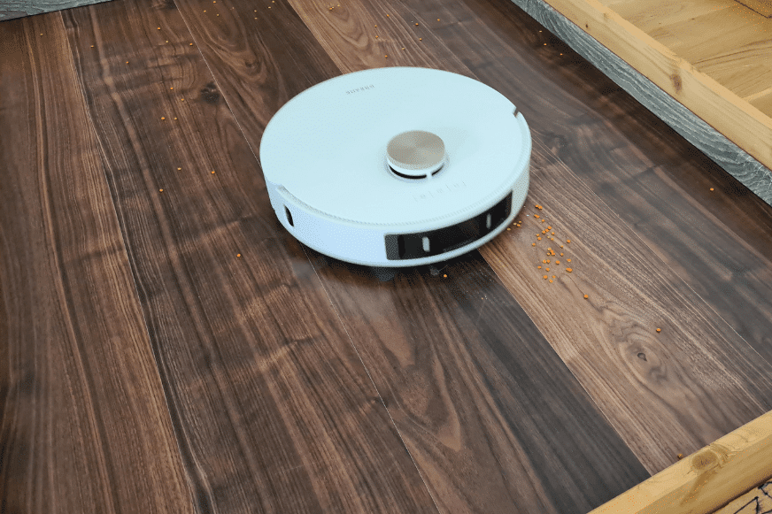 Пылесос Dreame L20 Ultra убирает чечевицу на ламинате во время теста.